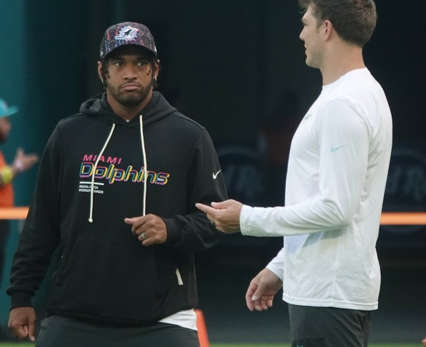 Miami Dolphins quarterback Tua Tagovailoa and quarterback Zach Wilson talk...