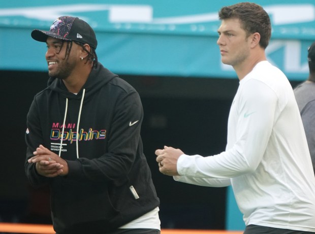 Miami Dolphins quarterback Tua Tagovailoa and Zach Wilson on Sunday,...