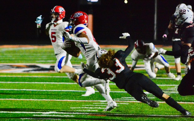 Neshaminy wide receiver Brock Williams, left, tries to get away...
