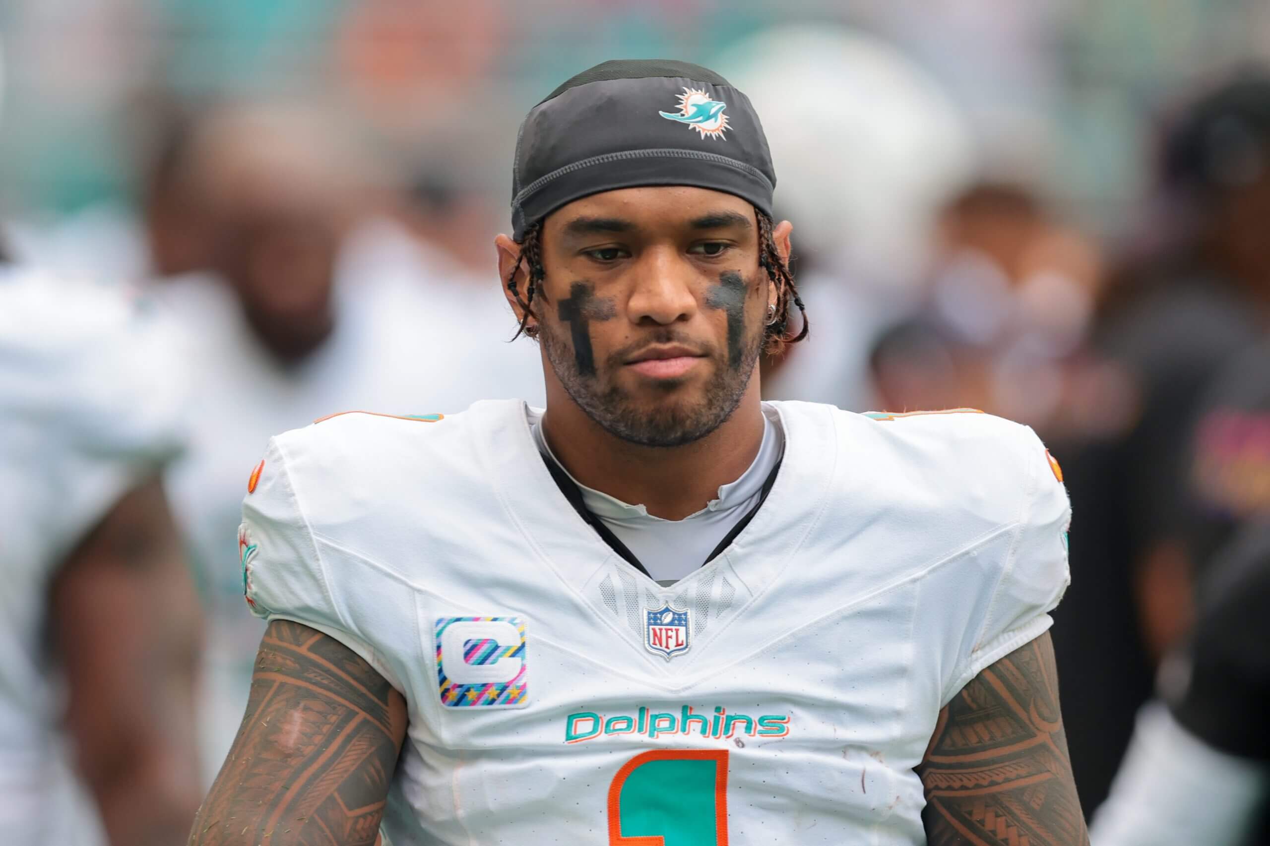Miami Dolphins quarterback Tua Tagovailoa (1) walks by the bench area against the Los Angeles Chargers during the fourth quarter at Hard Rock Stadium.