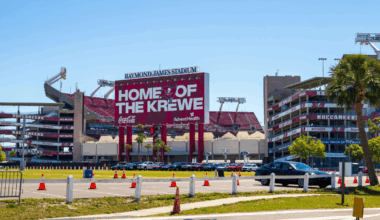 Exterior of Raymond James Stadium in Tampa, Florida, with “Home of the Krewe” signage and Buccaneers branding visible on a sunny day.