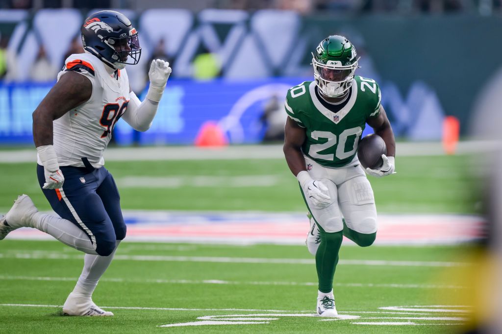 New York Jets running back Breece Hall (R) in action against Denver Broncos defensive end John Franklin-Myers (L).