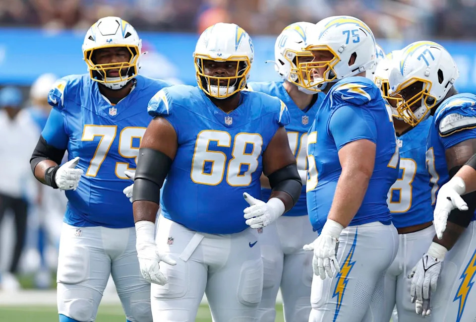 Chargers offensive linemen, including Jamaree Salyer (68) and Bradley Bozeman (75), stand on the field.