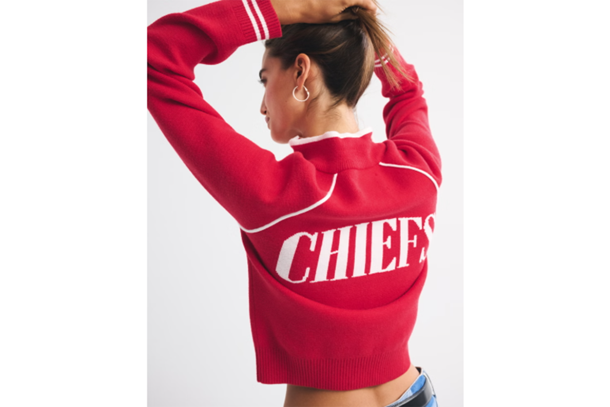 A woman wearing a red sweater with "CHIEFS" written across the back.