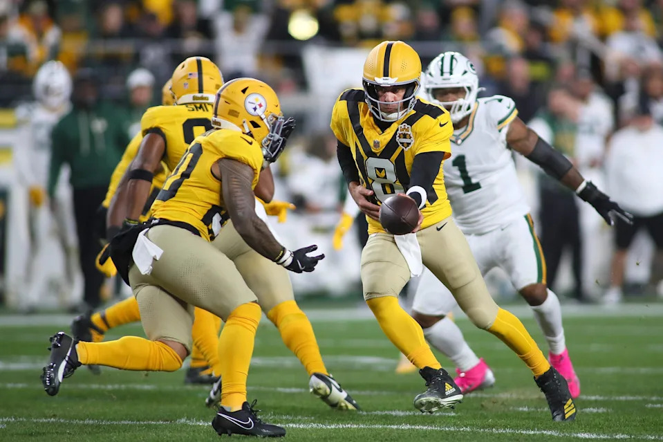 Pittsburgh Steelers quarterback Aaron Rodgers hands off the ball to running back Jaylen Warren.