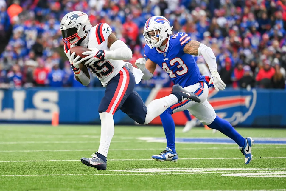 ORCHARD PARK, NEW YORK - DECEMBER 31: Ezekiel Elliott #15 of the New England Patriots carries the ball past Terrel Bernard #43 of the Buffalo Bills during the second half of the game at Highmark Stadium on December 31, 2023 in Orchard Park, New York. (Photo by Rich Barnes/Getty Images)