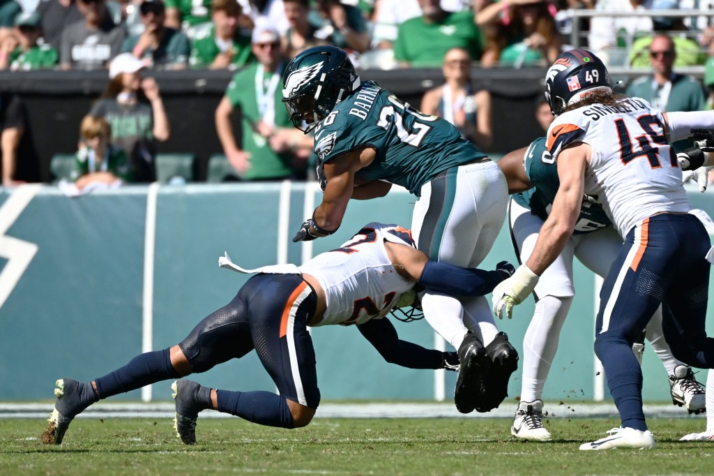 Denver Broncos safety Brandon Jones (22) tackling Philadelphia Eagles running back Saquon Barkley (26) in the second quarter.