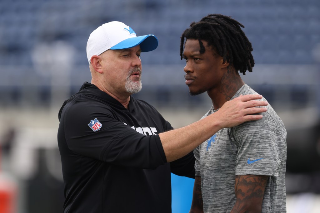 Detroit Lions offensive coordinator John Morton instructs wide receiver Jameson Williams (1) before a game.