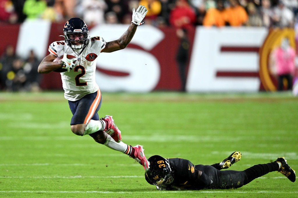 Bears wide receiver DJ Moore (2) evades a tackle attempt from the Commanders' Jeremy Reaves (39) on Oct. 13, 2025.