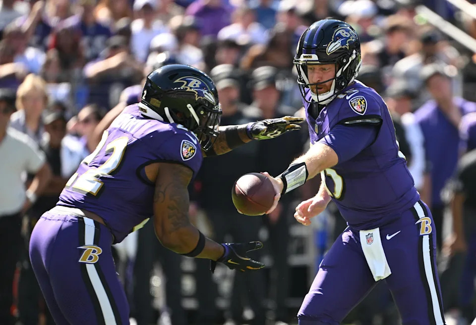 Oct 5, 2025; Baltimore, Maryland, USA; Baltimore Ravens quarterback Cooper Rush (15) hands the ball off to running back Derrick Henry (22) during the first quarter against the Houston Texans at M&T Bank Stadium. Mandatory Credit: Rafael Suanes-Imagn Images