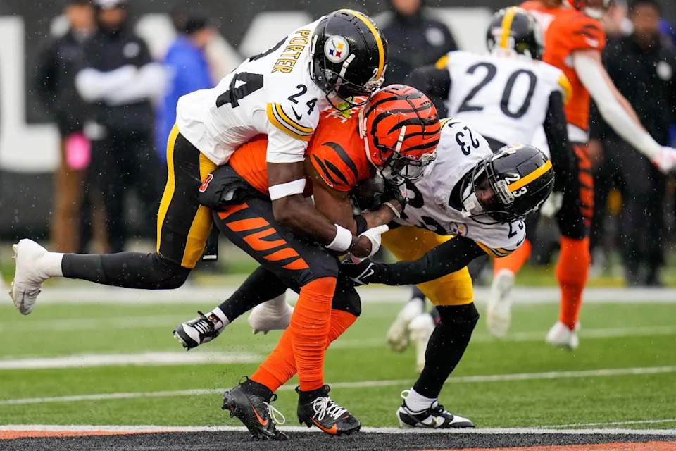 Cincinnati Bengals wide receiver Ja'Marr Chase (1) is pulled down by Pittsburgh Steelers cornerback Joey Porter Jr. (24) and safety Damontae Kazee (23) in the first quarter of the NFL Week 12 game between the Cincinnati Bengals and the Pittsburgh Steelers at Paycor Stadium in Cincinnati on Sunday, Nov. 26, 2023.