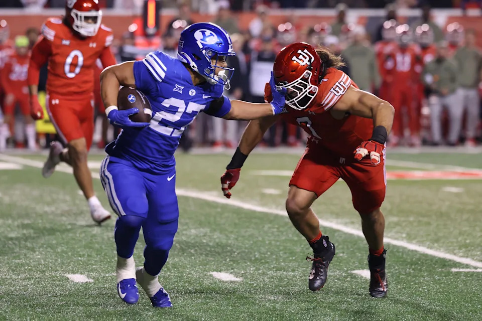 Nov 9, 2024; Salt Lake City, Utah, USA; Brigham Young Cougars running back LJ Martin (27) runs against Utah Utes defensive end Van Fillinger (7) during the second quarter at Rice-Eccles Stadium. Mandatory Credit: Rob Gray-Imagn Images