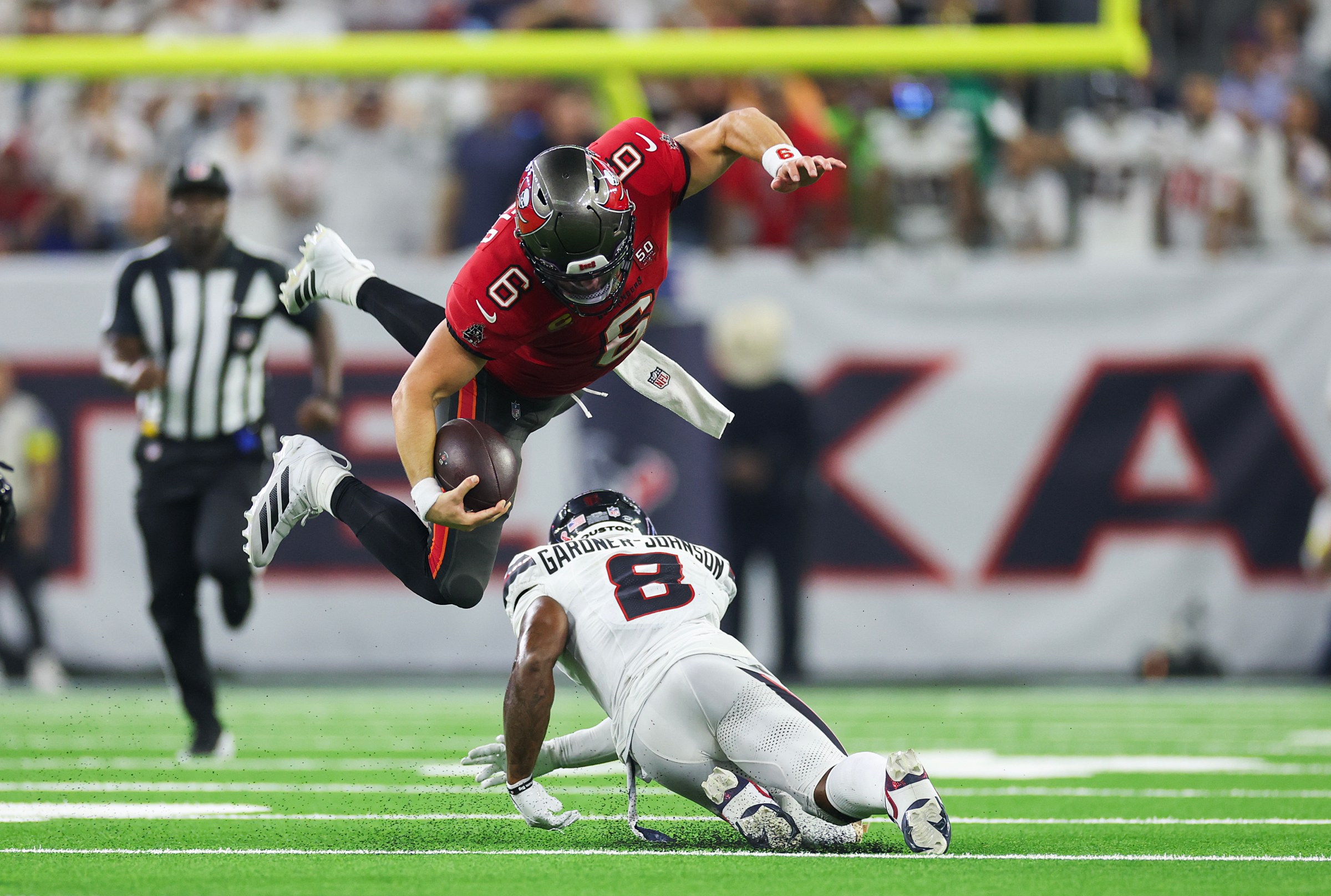 HOUSTON, TEXAS - SEPTEMBER 15: Baker Mayfield #6 of the Tampa Bay Buccaneers hurdles C.J. Gardner-Johnson #8 of the Houston Texans during the second half of an NFL football game against Houston Texans at NRG Stadium on September 15, 2025 in Houston, Texas. (Photo by Logan Bowles/Getty Images)