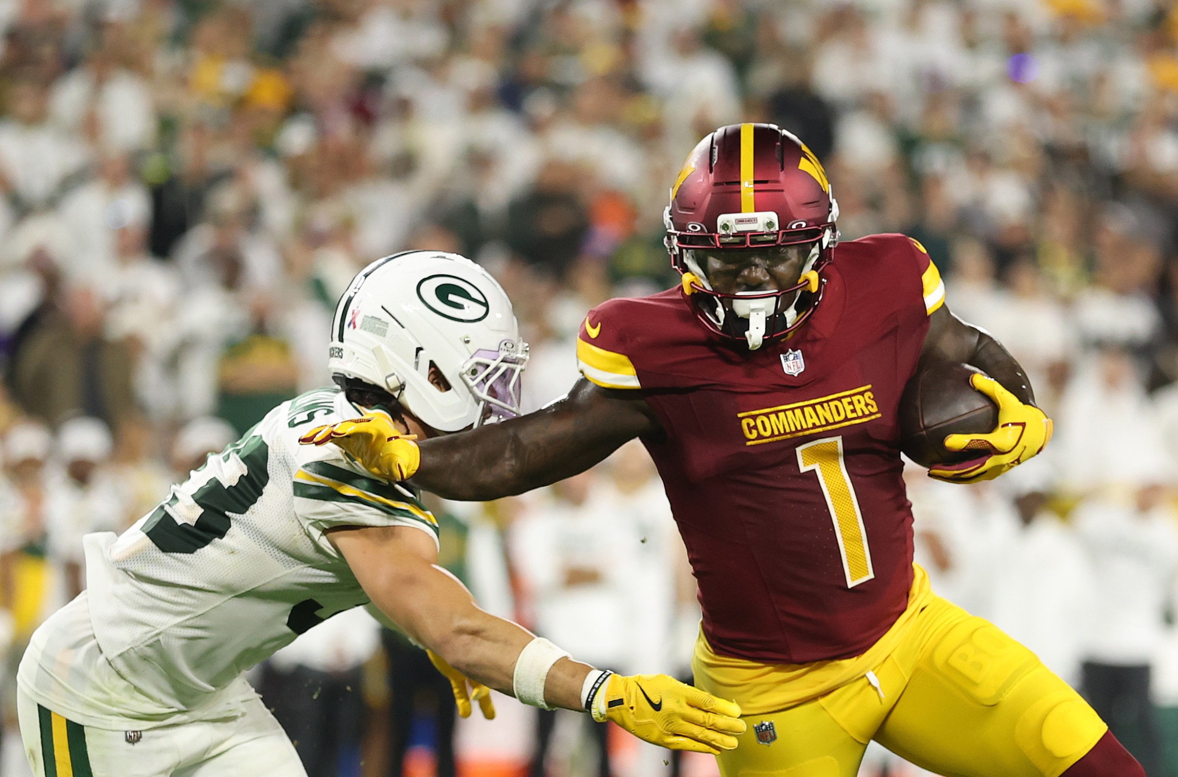 GREEN BAY, WISCONSIN - SEPTEMBER 11: Deebo Samuel #1 of the Washington Commanders stiff arms Evan Williams #33 of the Green Bay Packers at Lambeau Field on September 11, 2025 in Green Bay, Wisconsin. (Photo by Michael Reaves/Getty Images)