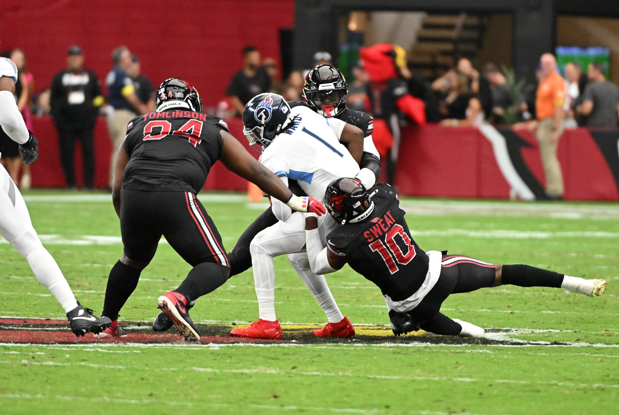 GLENDALE, ARIZONA - OCTOBER 05: Cam Ward #1 of the Tennessee Titans is sacked by Baron Browning #5 and Josh Sweat #10 of the Arizona Cardinals during the NFL 2025 game at State Farm Stadium on October 05, 2025 in Glendale, Arizona. (Photo by Norm Hall/Getty Images)
