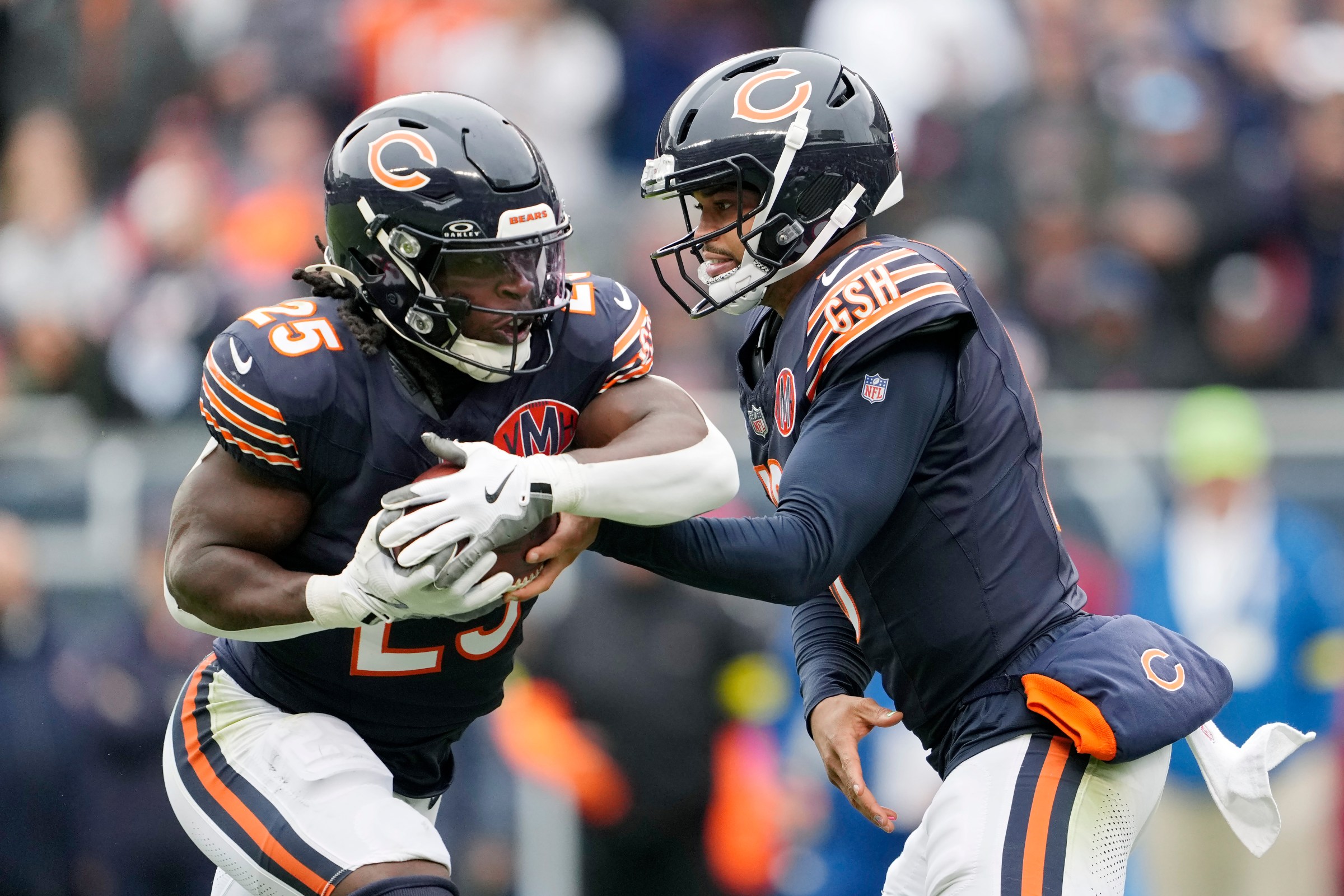 CHICAGO, ILLINOIS - OCTOBER 19: Caleb Williams #18 of the Chicago Bears hands off the ball to teammate Kyle Monangai #25 during the first half of the game against the New Orleans Saints at Soldier Field on October 19, 2025 in Chicago, Illinois. (Photo by Patrick McDermott/Getty Images)