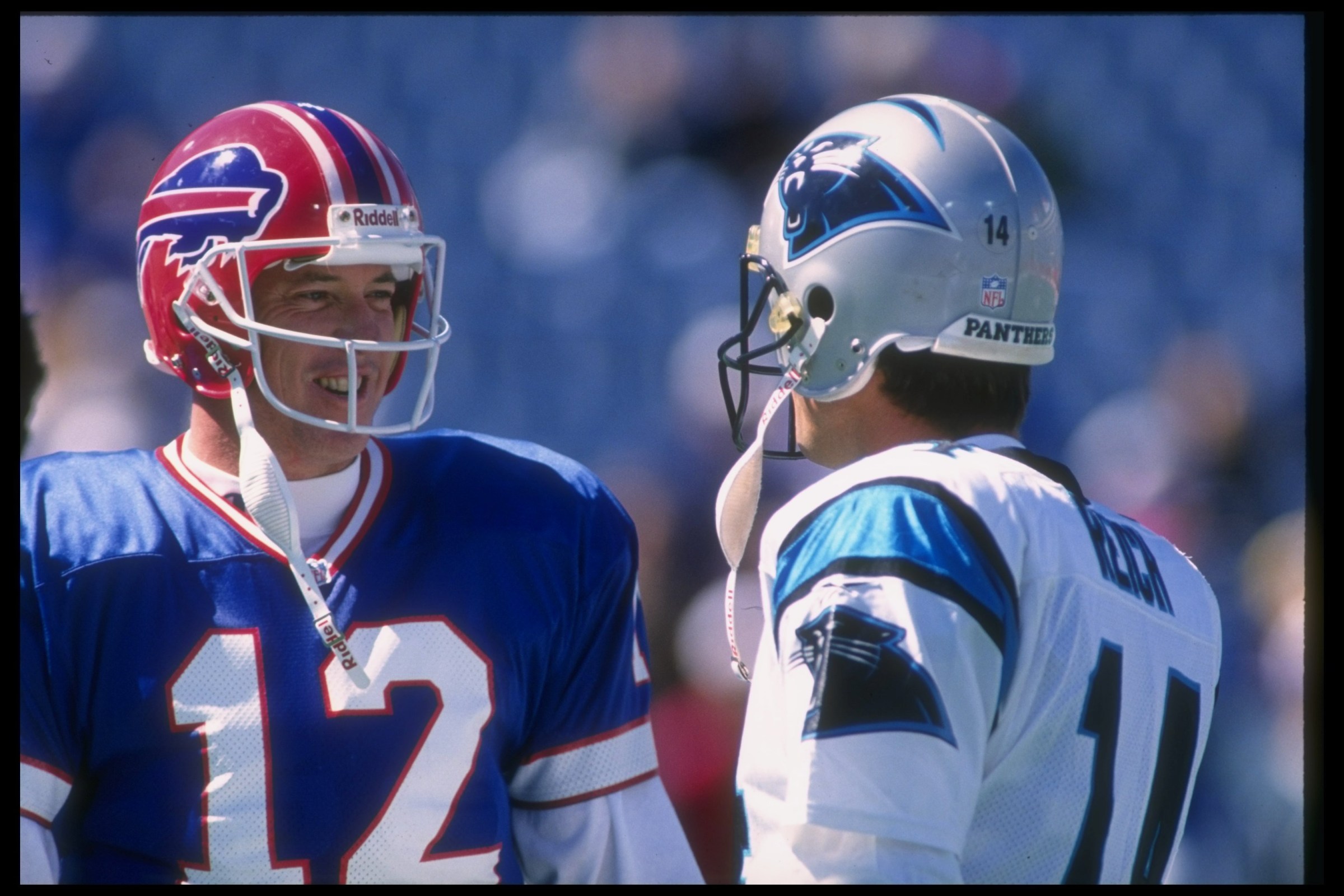 10 Sep 1995: Quarterback Jim Kelly of the Buffalo Bills (left) confers with Carolina Panthers quarterback Frank Reich during a game at Rich Stadium in Orchard Park, New York. The Bills won the game, 31-9.