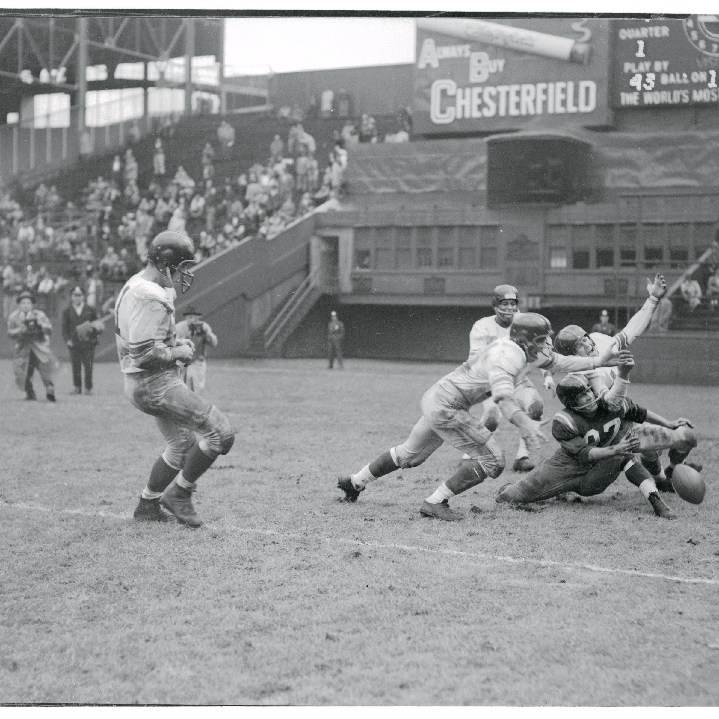 (Original Caption) Slipped Through His Fingers. New York: Washington Redskin End Ralph Thomas is mobbed by New York Giant players as he drops a pass from Redskin Back Eddie Lebaron in the first quarter at the polo grounds today. Giants won, 35-7.