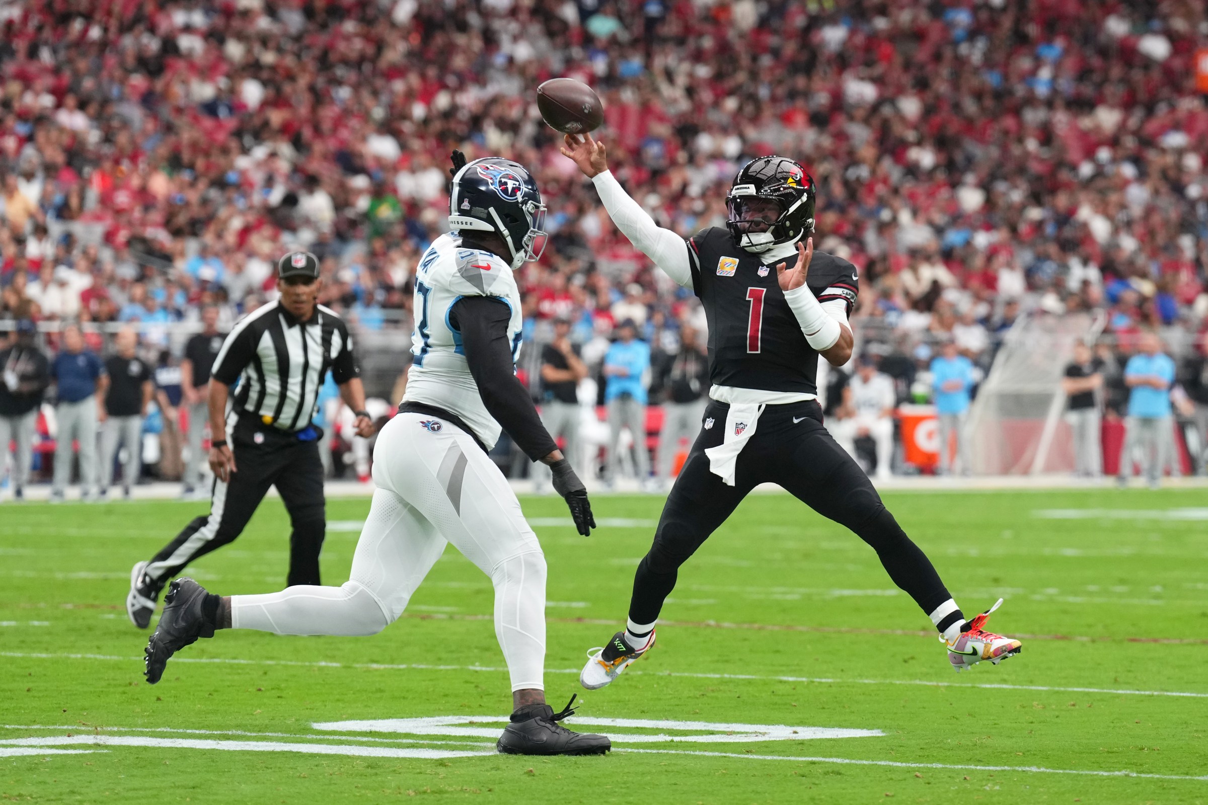 Oct 5, 2025; Glendale, Arizona, USA; Arizona Cardinals quarterback Kyler Murray (1) throws a pass while pressured by Tennessee Titans linebacker Cedric Gray (33) during the first quarter at State Farm Stadium. Mandatory Credit: Joe Camporeale-Imagn Images