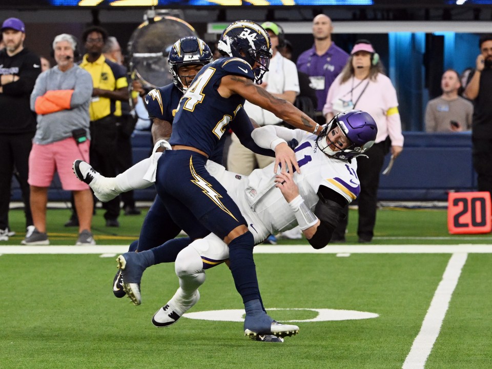 Minnesota Vikings quarterback Carson Wentz (11) gets knocked down after throwing a pass during an NFL football game against the Los Angeles Chargers