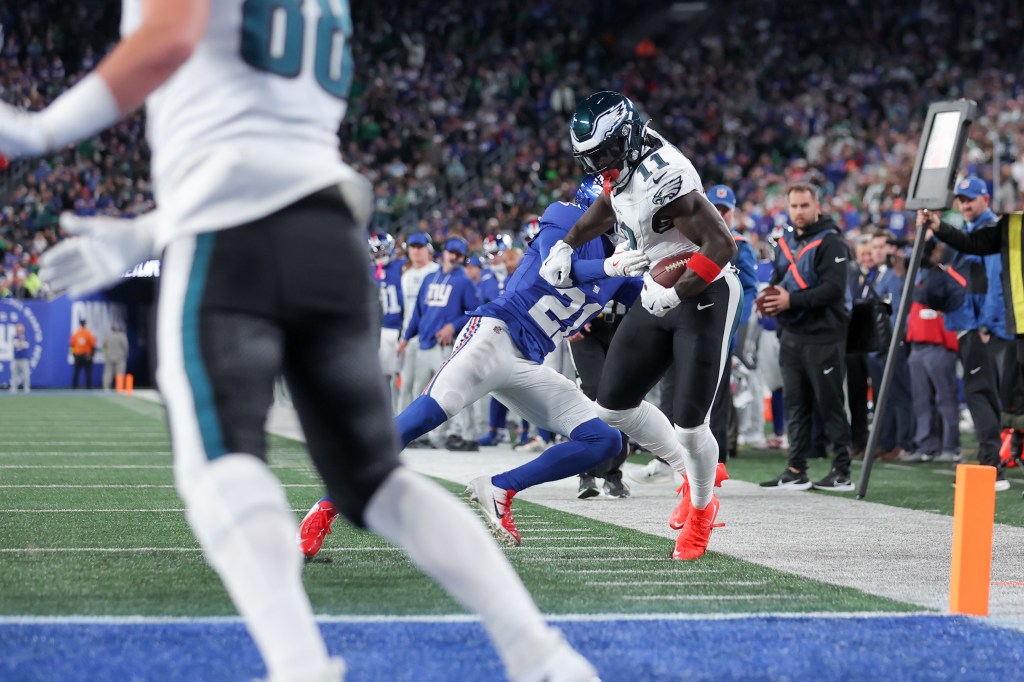 Philadelphia Eagles wide receiver A.J. Brown (11) is pushed out of bounds by New York Giants cornerback Paulson Adebo (21).