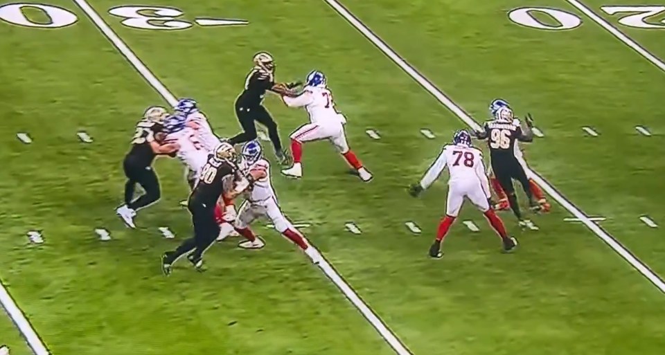 Football players in white and black jerseys on a green field.