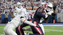 New England Patriots wide receiver Stefon Diggs gets about 10 yards on the play while Buffalo Bills cornerback Taron Johnson tries to take him down with teammate Buffalo Bills safety Taylor Rapp coming in to assist during second half action at Highmark Stadium in Orchard Park on Oct. 5, 2025.