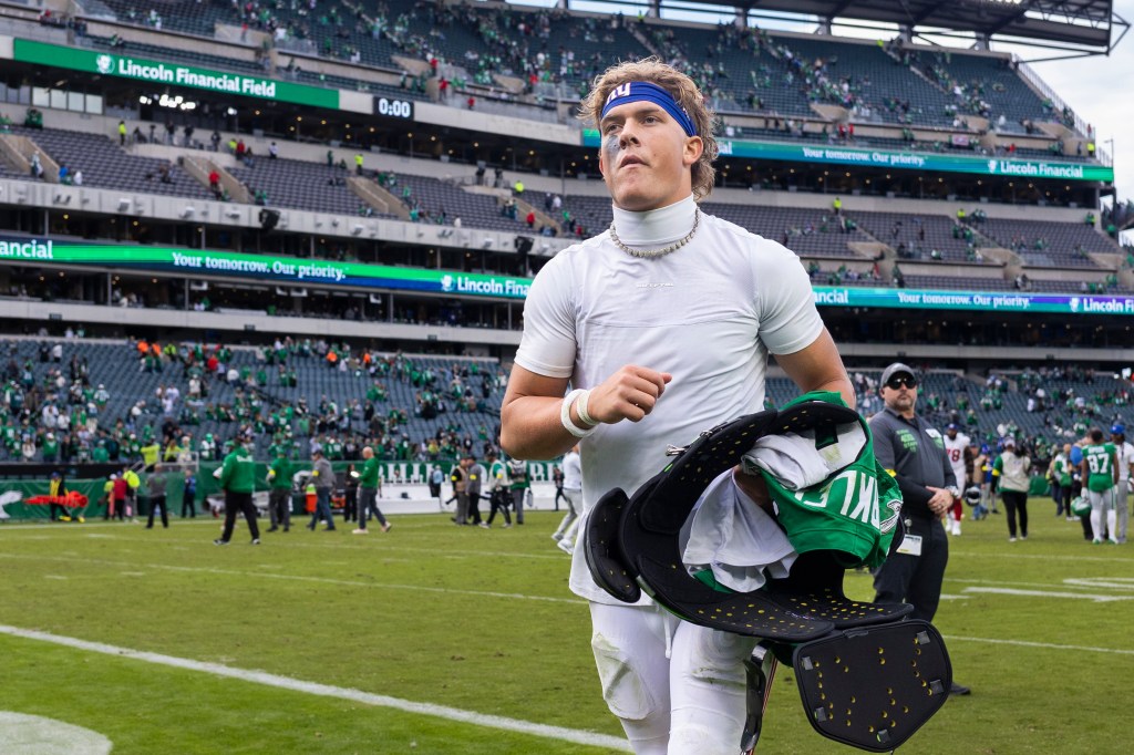 New York Giants quarterback Jaxson Dart (6) holding Saquon Barkley's jersey after the game.