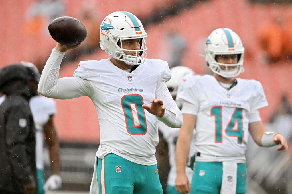 Dolphins QBs Zach Wilson (0) and Quinn Ewers (14) warm up before a game against the Browns on Oct. 19, 2025.