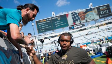 Jacksonville Jaguars defensive end Travon Walker (44) signs autographs before an NFL football game at EverBank Stadium, Sunday, November 16, 2025, in Jacksonville, Fla.