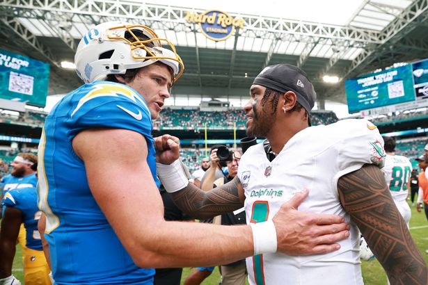 Tua Tagovailoa #1 of the Miami Dolphins and Justin Herbert #10 of the Los Angeles Chargers embrace after the game at Hard Rock Stadium on October 12, 2025 in Miami Gardens, Florida.