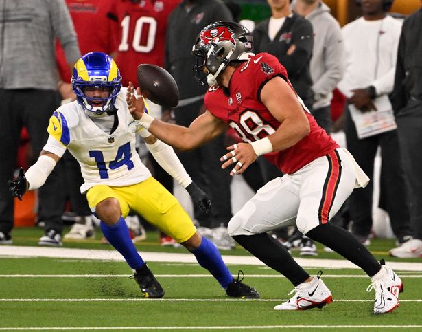 Tight end Cade Otton (88) of the Tampa Bay Buccaneers can't control the ball as cornerback Cobie Durant (14) of the Los Angeles Rams intercepts and runs for the touchdown in the first half of an NFL football game at SoFi Stadium in Inglewood on Sunday, November 23, 2025