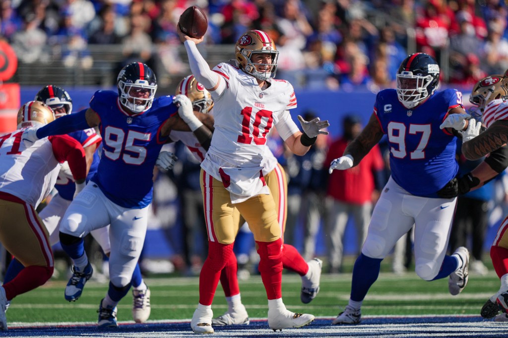 San Francisco 49ers quarterback Mac Jones (10) throws a pass while pressured by New York Giants defensive tackles Roy Robertson-Harris (95) and Dexter Lawrence II (97).