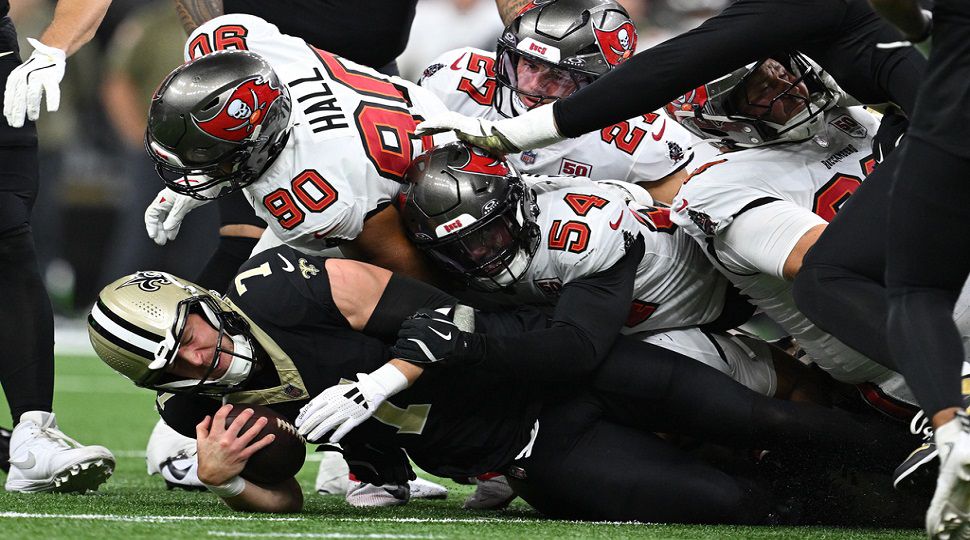 New Orleans Saints quarterback Taysom Hill (7) is sacked by Tampa Bay Buccaneers linebacker Lavonte David (54) and defensive end Logan Hall (90) during the second half of an NFL football game Sunday, Oct. 26, 2025, in New Orleans. (AP Photo/Ella Hall)