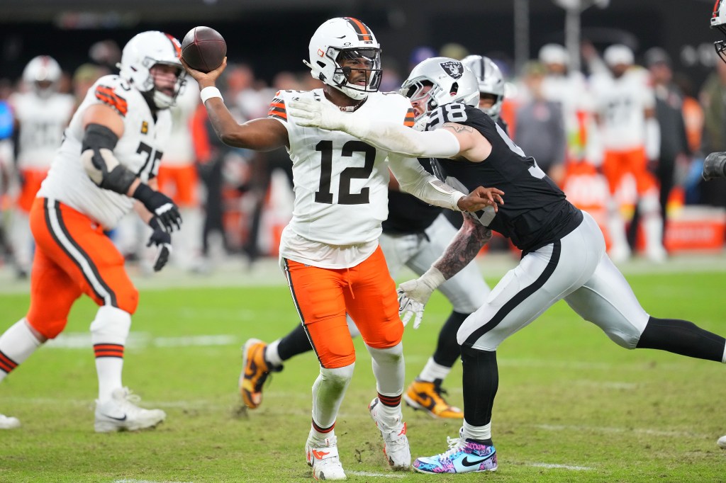 Cleveland Browns quarterback Shedeur Sanders (12) looks to make a pass attempt as Las Vegas Raiders defensive end Maxx Crosby (98) tackles him during the third quarter at Allegiant Stadium on November 23, 2025.