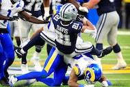 Dallas Cowboys running back Malik Davis (21) is spun around and tackled by Los Angeles Rams...