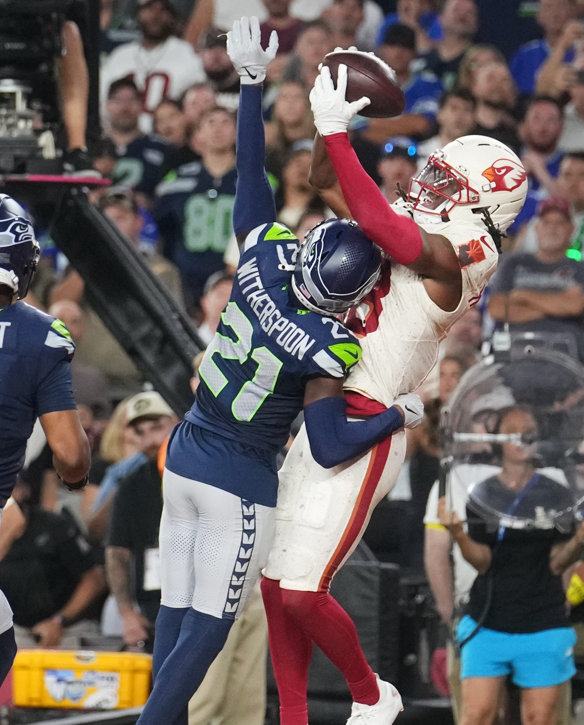 Arizona Cardinals receiver Marvin Harrison Jr. (18) catches a touchdown pass as Seattle Seahawks cornerback Devon Witherspoon (21) defends at State Farm Stadium in Glendale on Sept. 25, 2025.
