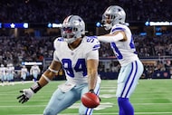 Dallas Cowboys defensive end Marshawn Kneeland (94) celebrates with Malik Davis (43), after...