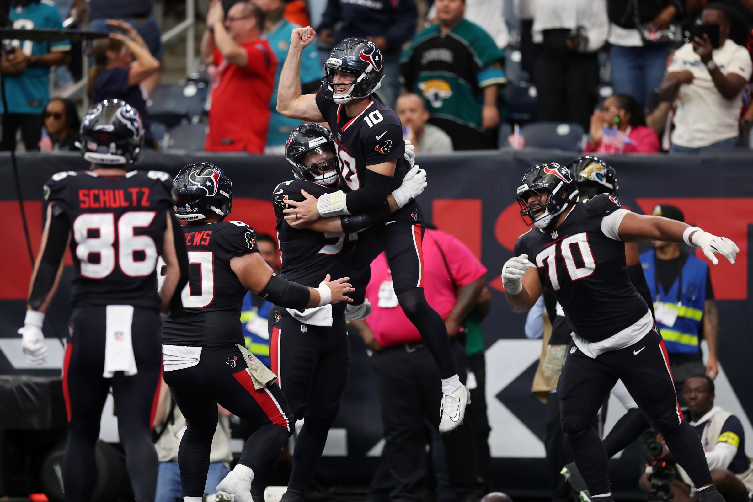 HOUSTON, TEXAS - NOVEMBER 09: Davis Mills #10 of the Houston Texans is congratulated by his teammates after running the ball for a touchdown against the Jacksonville Jaguars during the second half in the game at NRG Stadium on November 09, 2025 in Houston, Texas. (Photo by Tim Warner/Getty Images)