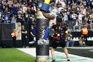 Dallas Cowboys wide receiver George Pickens (3) jumps onto the goalpost as he celebrates a...