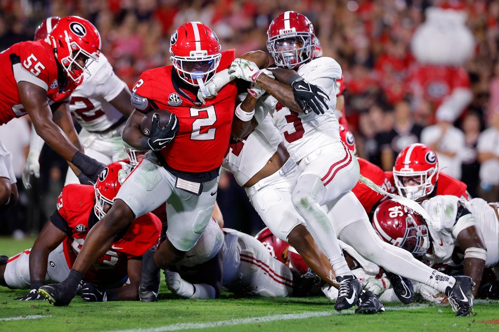 Josh McCray #2 of the Georgia Bulldogs runs with the ball while being tackled by Keon Sabb #3 of the Alabama Crimson Tide during the third quarter at Sanford Stadium on September 27, 2025 in Athens, Georgia. 