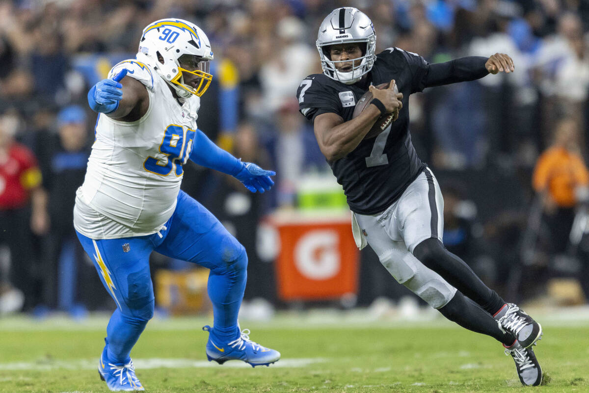 Raiders quarterback Geno Smith (7) runs as he tries to escape pressure from Los Angeles Charger ...