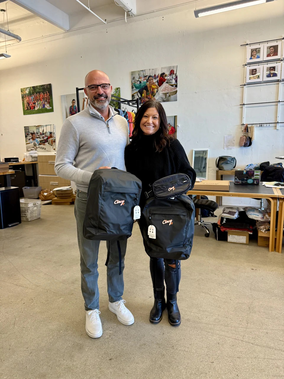 Founders of the Aruna Project, Ryan and April Berg, with The Cincy Hat Foundation-themed Aruna belt bags and backpack.