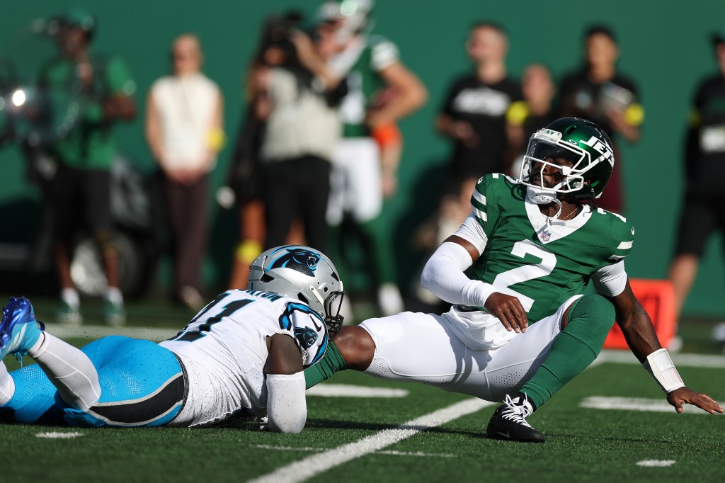 New York Jets player #2 on the ground, with a Carolina Panthers player also on the ground in front of him.