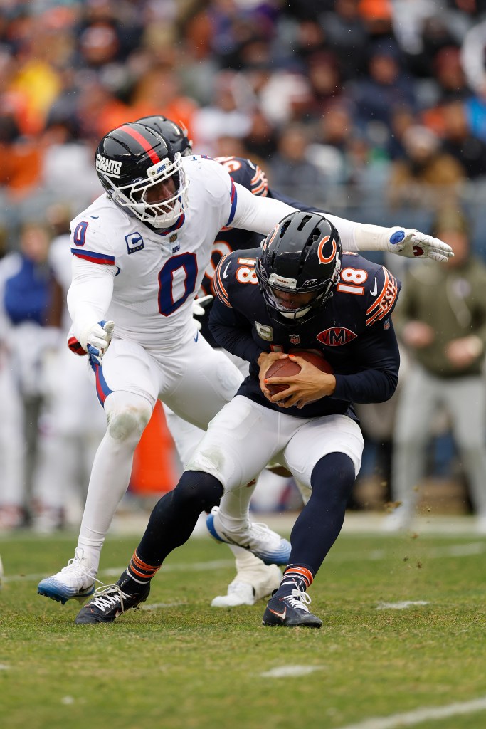 Caleb Williams #18 of the Chicago Bears avoids a tackle by Brian Burns #0 of the New York Giants during the third quarter in the game at Soldier Field on November 09, 2025 in Chicago, Illinois.