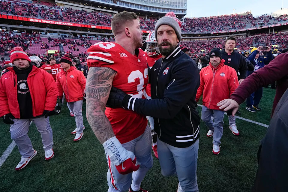 Linebackers coach James Laurinaitis pulls defensive end Jack Sawyer (33) out of the melee.