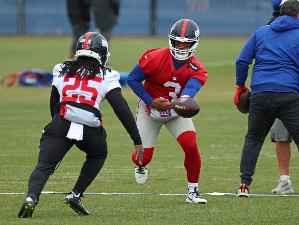 New York Giants quarterback Russell Wilson #3 handing the ball off to running back Dante Miller #25 during practice.