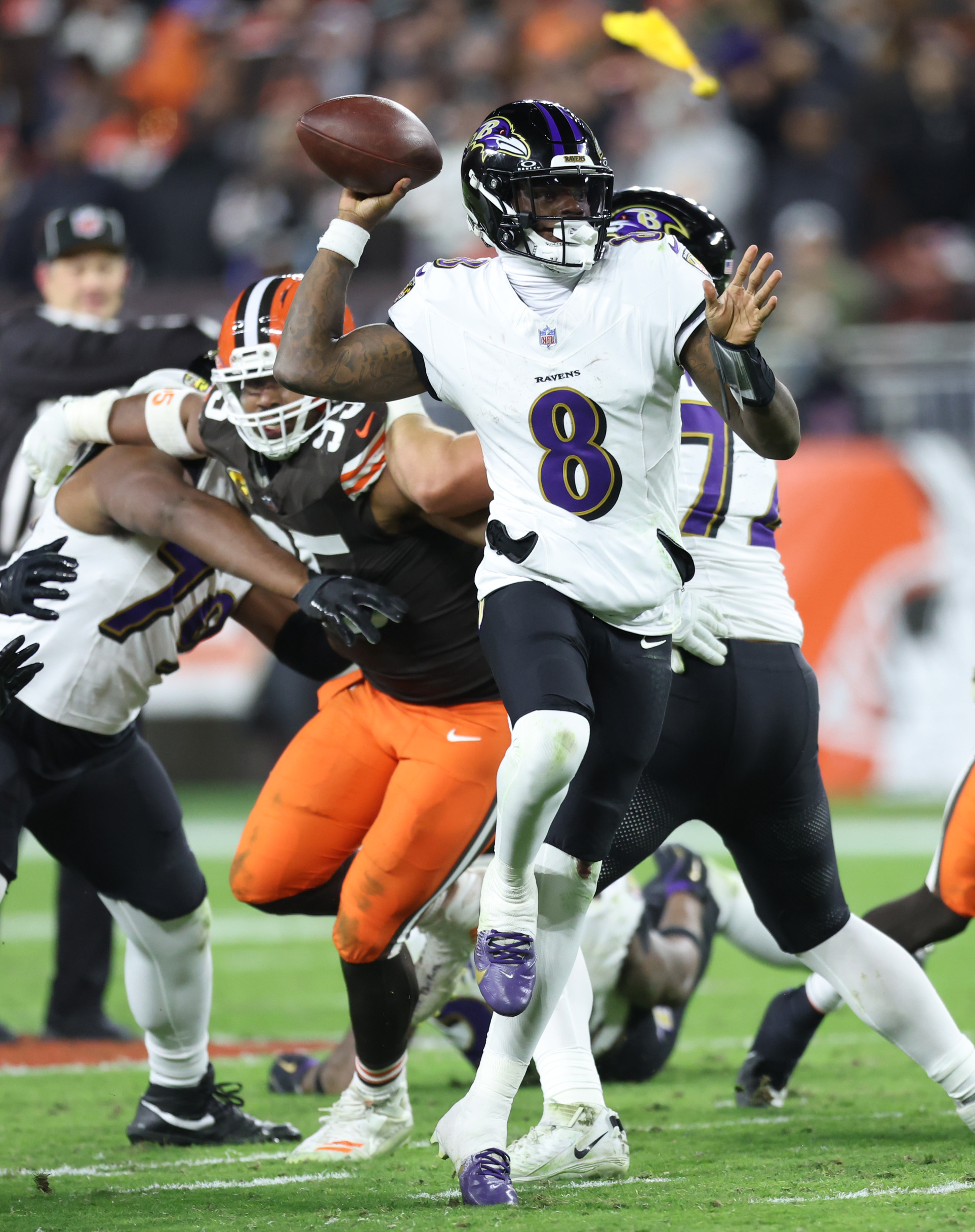 Baltimore Ravens quarterback Lamar Jackson prepares to throw a pass as Baltimore Ravens offensive tackle Ronnie Stanley holds Cleveland Browns defensive end Myles Garrett for the penalty in the third quarter. 