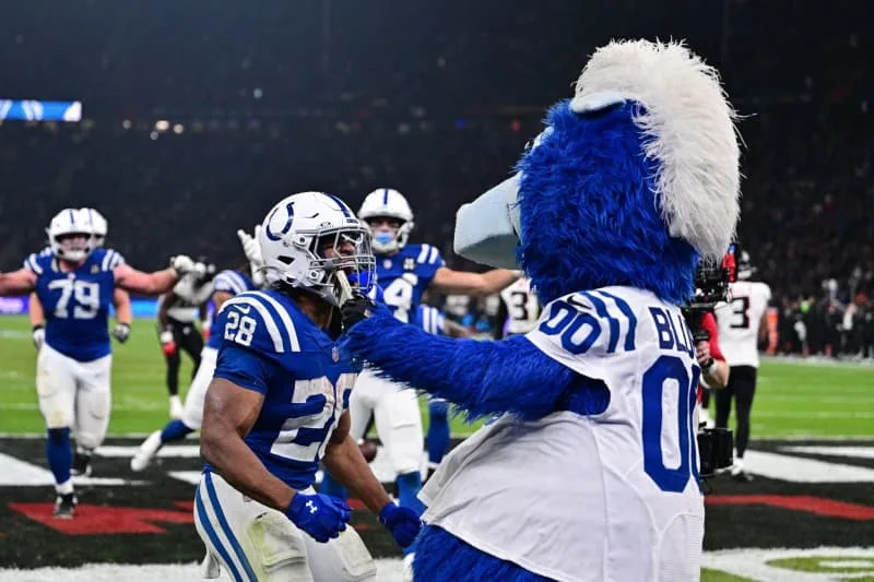 Indianapolis Colts' Jonathan Taylor (L) celebrates victory in overtime after his third touchdown with Blue, the official mascot of the Indianapolis Colts after the NFL American football match between Indianapolis Colts and Atlanta Falcons at Olympiastadion Berlin. Sebastian Christoph Gollnow/dpa