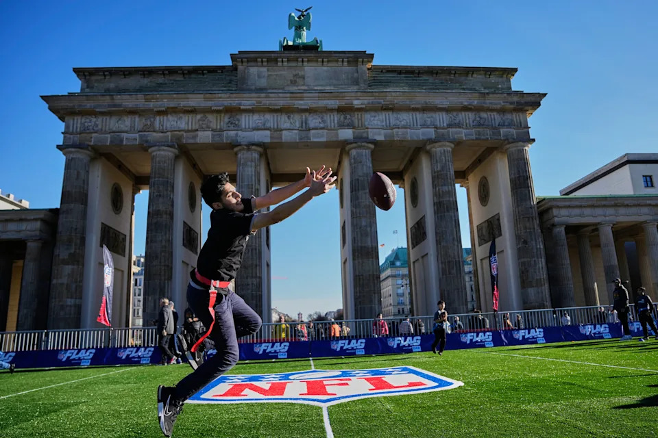Children play flag football on a mini flag football field, set up in front of the Brandenburg Gate in Berlin, Germany, Thursday, Nov. 6, 2025, during an event promoting the NFL ahead of the upcoming game between the Indianapolis Colts and the Atlanta Falcons. (AP Photo/Ebrahim Noroozi)